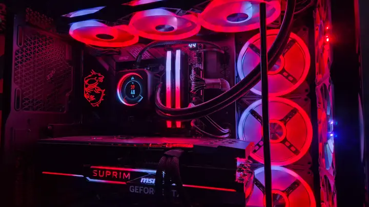 Innenansicht eines PC-Systems mit rot beleuchteten Lüftern und Wasserkühlung
